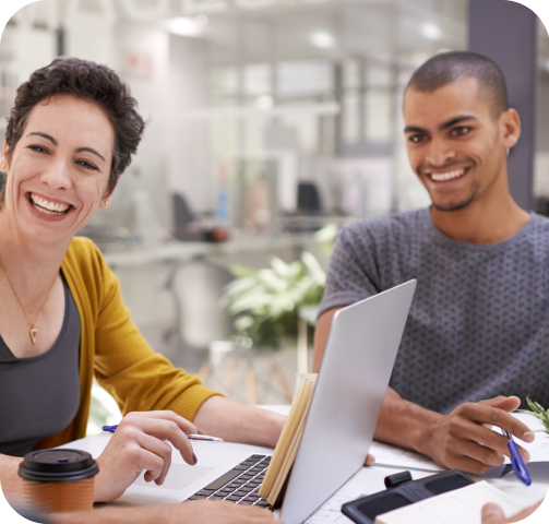 Smiling co-workers discussing HCP digital marketing in a meeting.